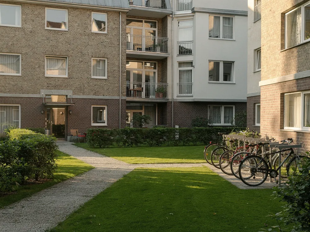 Begrünter Innenhof einer Wohnanlage mit gepflegtem Rasen und Fahrradständern